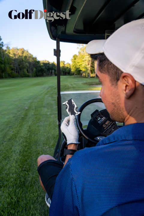 a man in a golf cart holding a card sized pocket tripod