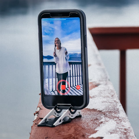 iPhone taking a video on a Pocket Tripod on the ledge of a balcony.