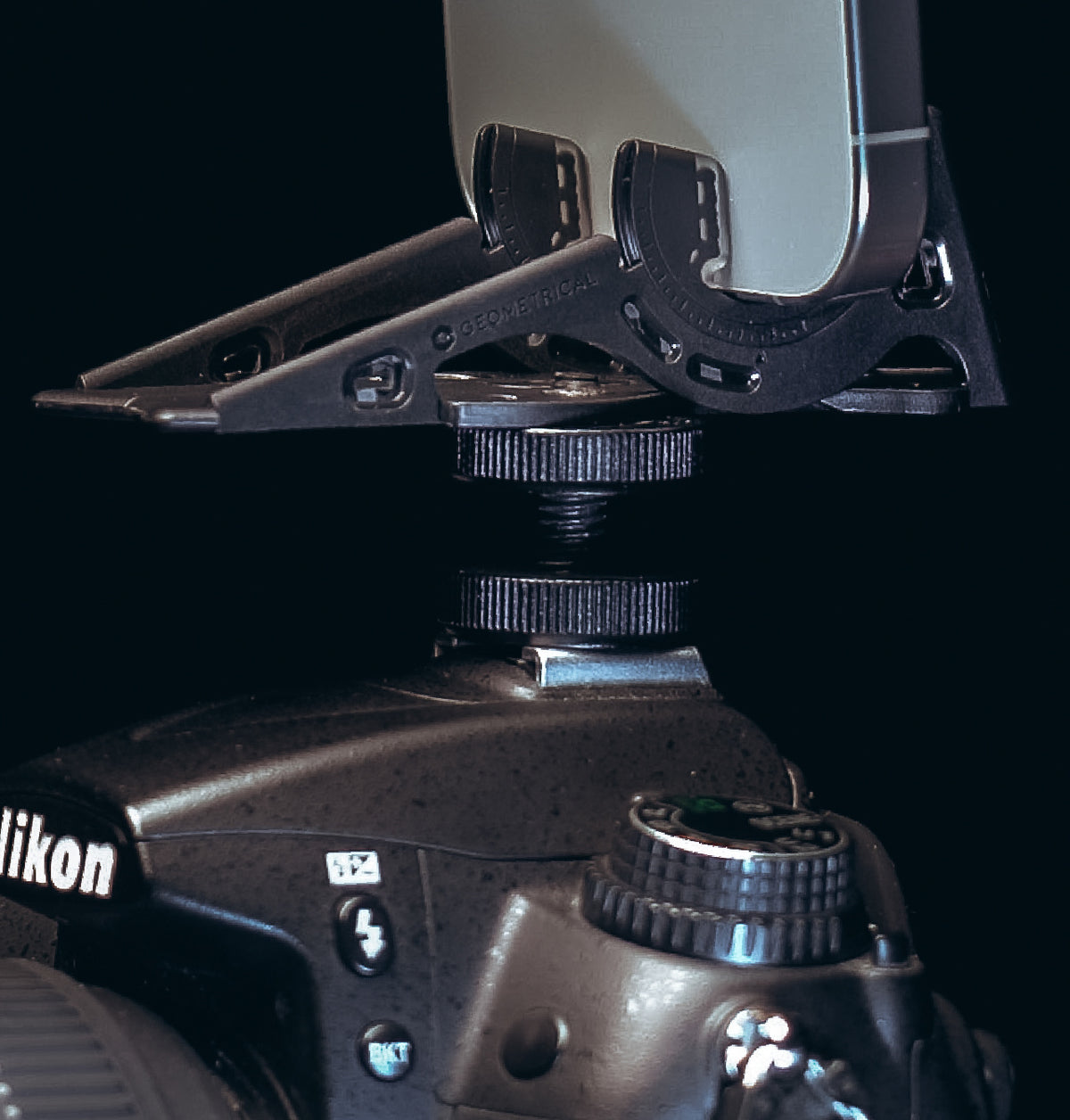 The Pocket Tripod mounted on a DSLR's hot shoe, holding a phone