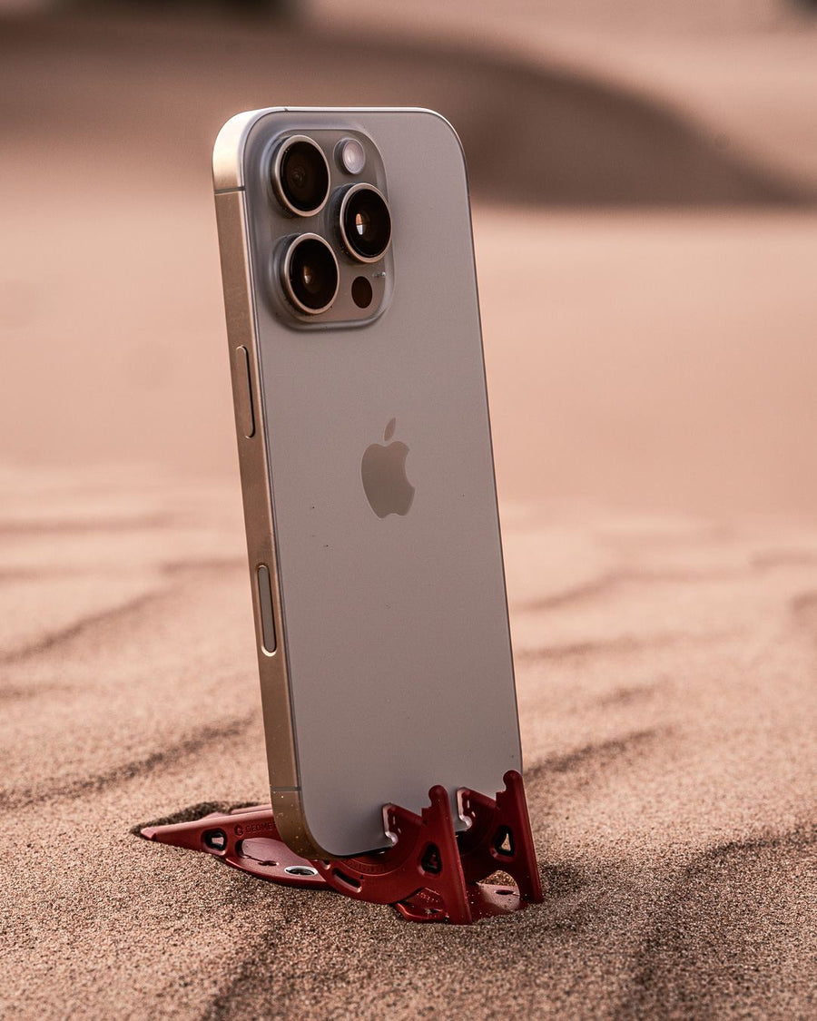 A red Pocket Tripod on sand
