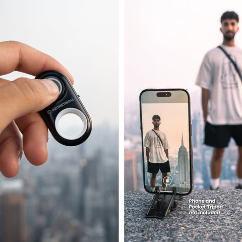 Hand holding a phone remote with smartphone displaying a person taking a photo in the background.