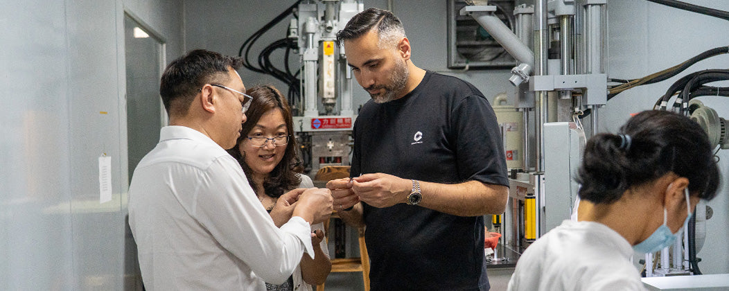 Rambod with the production team, inspecting Pocket Tripod parts on the line